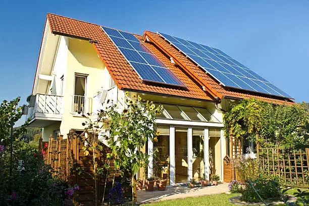 Szenische Darstellung eines Hauses mit Solarpaneelen auf dem Dach